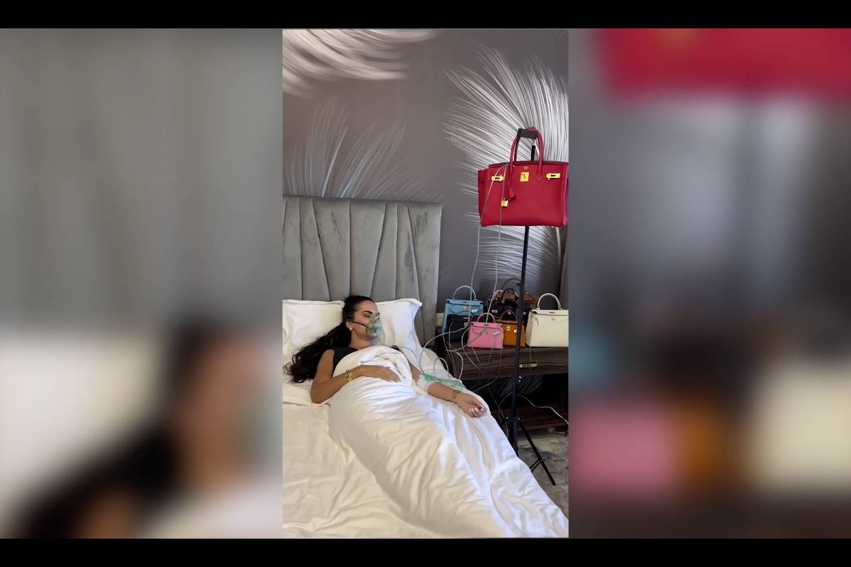 Giulia Nati nel letto con mascherina e flebo, collegate a borse Hèrmes.